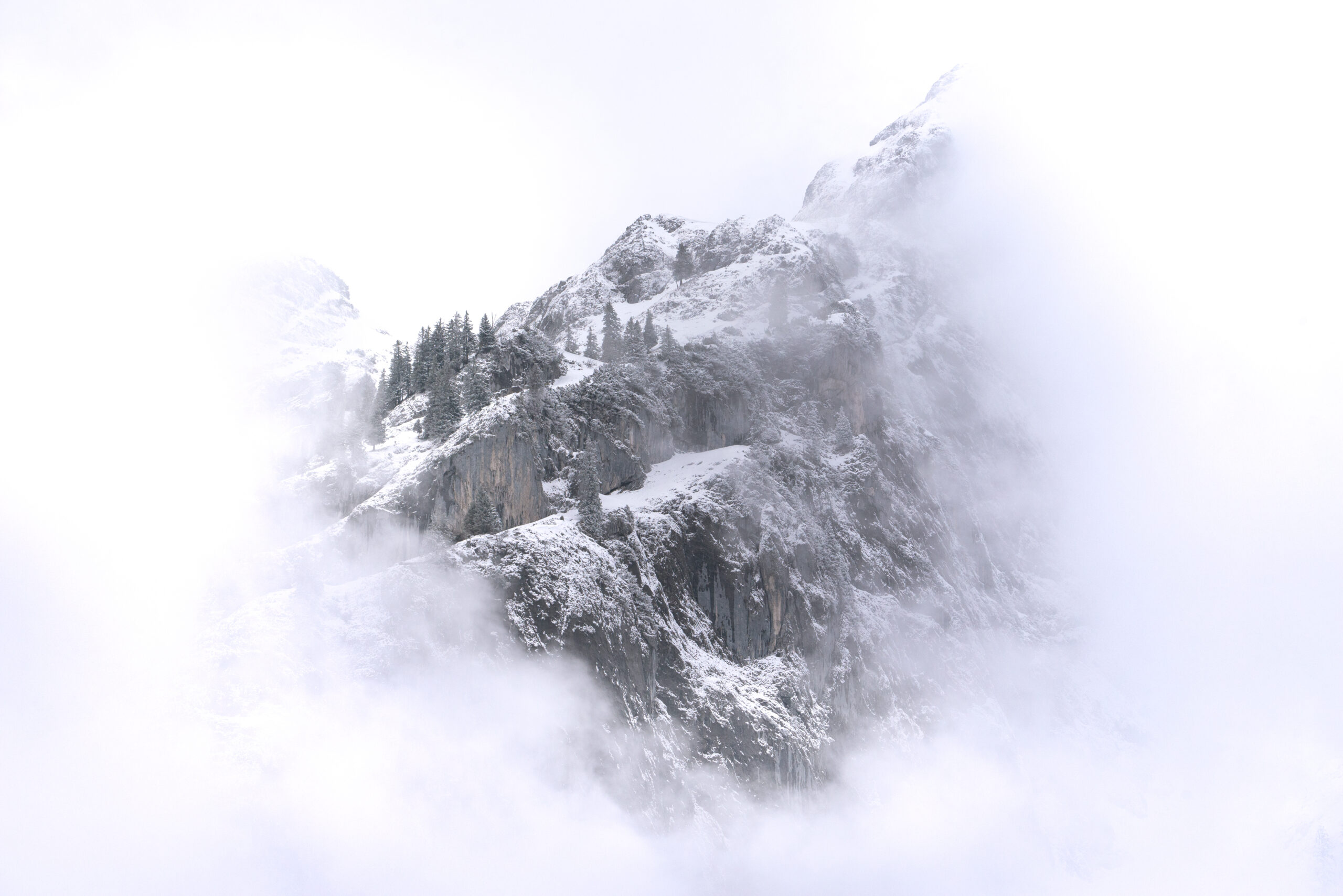 Close up of snowy mountain peak in fog